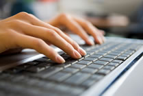 hands typing on computer keyboard