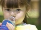 Little girl drinking bottle water.