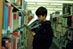 Photo by Laura Houpy: Boy reading in the library book aisle