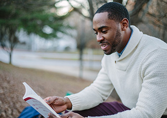 man reading book outside