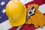 Labor Day photo composite: work gloves, hat and wrench on an American flag