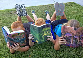 kids reading books in the grass