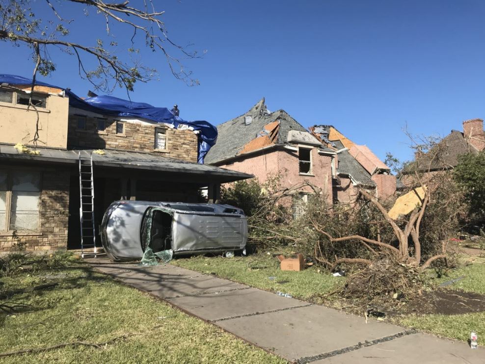 Destroyed home with car fallen into the home.