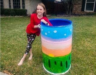 Girl leaning against trash she painted